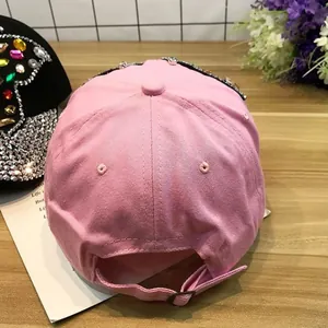 Détail d'une casquette rose en jean avec strass colorés et boucle en métal ajustable