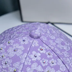 Macro shot of purple floral relief fabric and sparkling rhinestones on the baseball cap