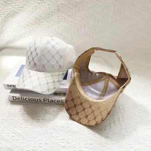 Detail of vintage jacquard sun hats with rhinestone letter R and classic brown monogram pattern