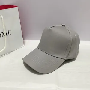 Detail view of a gray five-panel cotton baseball cap with reinforced stitching on the brim