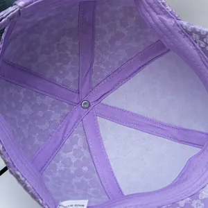 Detailed interior view of purple floral baseball cap with reinforced seams and care label