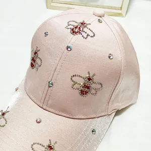 Detail of pink satin baseball cap with sparkling rhinestone bee motifs and crystals