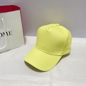 Detailed stitching and fabric texture of a bright yellow cotton baseball cap with copper buckle