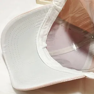 Detail of pink baseball cap with transparent protective shield and reinforced white stitching