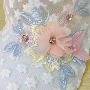 Dettaglio cappello in pizzo bianco con fiori 3D in chiffon e perle decorative