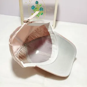 Detail view of pink cotton baseball cap interior with adjustable silver metal buckle strap
