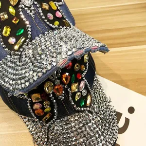 Détail macro d'une casquette en jean avec strass colorés et papillon en cristal de luxe