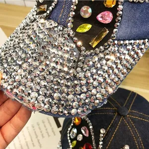 Gros plan de cristaux colorés et strass brillants sur une casquette en jean bleu