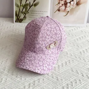 Detail of purple floral baseball cap with jacquard fabric and rhinestone heart brooch