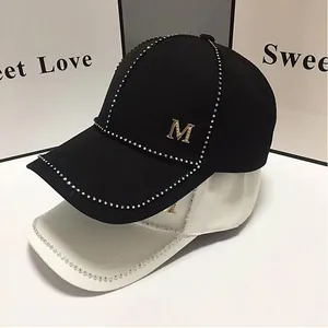 Détails de strass étincelants et de la lettre M dorée sur une casquette de baseball