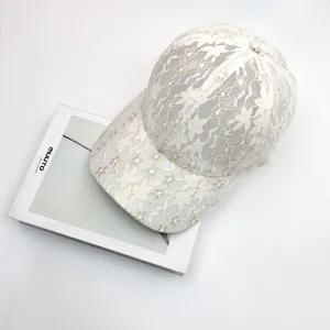 Close-up of white lace baseball cap featuring intricate floral mesh and breathable patterns