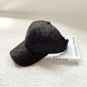 Detailed view of black jacquard fabric with rhinestones and letter pattern on a sun hat