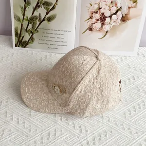 Detailed view of beige lace baseball cap featuring exquisite heart floral metal ornaments