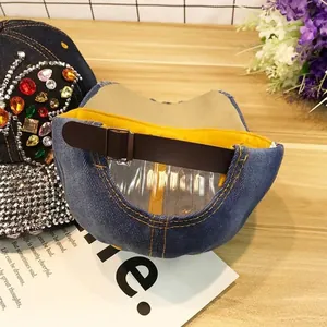 Détail de papillon en strass colorés sur une casquette de baseball en jean