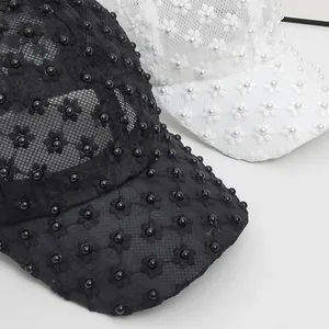 Close-up of elegant floral lace mesh with pearl beads on women's baseball caps