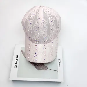 Détail de la casquette de baseball en dentelle rose avec strass brillants et texture fine