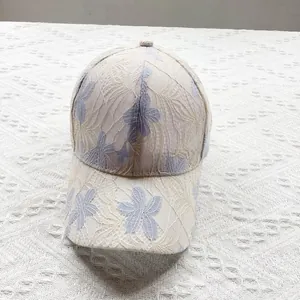 Close-up of breathable beige lace fabric and light blue floral embroidery on baseball cap