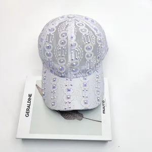 Détail de la casquette de baseball en dentelle violet clair ornée de strass brillants