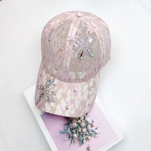 Detailansicht der rosa Blumen-Spitzenkappe mit Schmetterlings-Strassverzierung