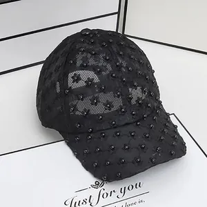 Detailed side view of black lace baseball cap featuring elegant pearls and floral embroidery