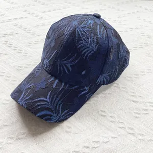 Detail of navy blue lace baseball cap featuring floral hollow-out embroidery and mesh texture