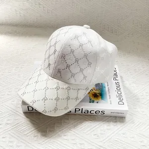 Close-up of white sun hat with rhinestone R patterns on a decorative book background