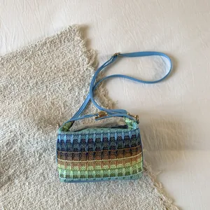 Borsa a secchiello a righe colorate con tracolla blu e chiusura a scatto dorata