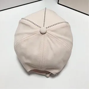 Gros plan d'une casquette beige en coton avec des strass brillants sur les coutures