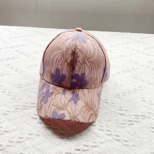 Detailed close-up of pink floral lace embroidery and breathable mesh on baseball cap