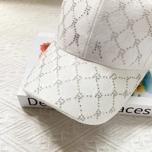 Detail of white jacquard sun hat featuring shimmering rhinestones and textured fabric finish