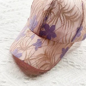 Close-up of pink lace baseball cap with floral embroidery and breathable mesh texture