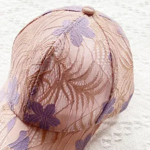 Close-up of floral lace embroidery and premium stitching on a pink mesh sun hat