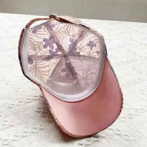 Detail of pink floral lace baseball cap showing inner structure and adjustable strap