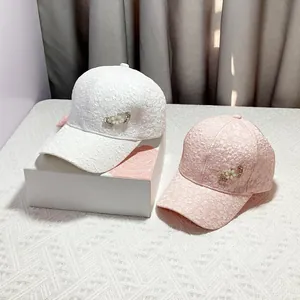 Detail of floral lace baseball caps with rhinestone double hearts in white and pink