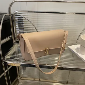 Chic beige rectangular shoulder bag with golden twist lock on a modern display stand