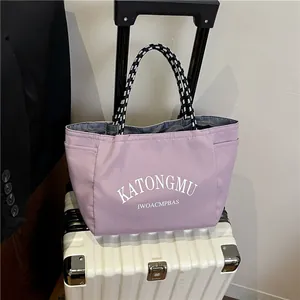 Lavender purple tote bag with braided handles displayed on a white suitcase