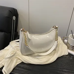 Sac sous le bras chic en cuir verni crème avec chaîne dorée pour l'été 2025