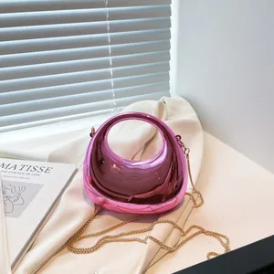 Glossy rose red dumpling bag with circular handle and gold chain strap in studio setting