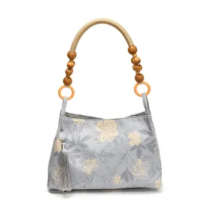 Sac cabas en toile bleue à motif floral avec anses en perles de bois et gland gris