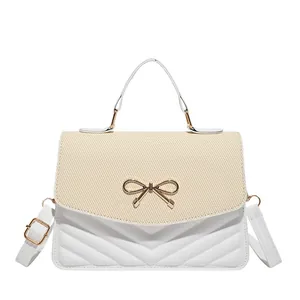 Sac bandoulière chic en paille tressée et cuir avec nœud doré et motif à chevrons