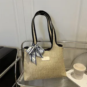 Summer woven beach tote bag in beige with black handles and blue striped silk scarf