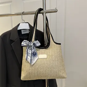 Handwoven straw tote bag with black leather trim and decorative Paris print silk scarf