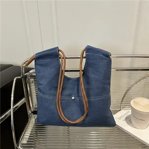 Minimalist navy denim tote bag with contrast stitching and brown rope handles
