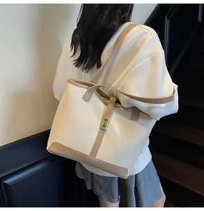 Detail view of large contrast tote bag with golden twist lock and premium leather texture