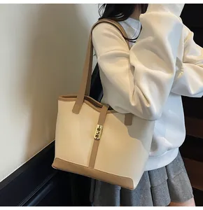 Detail of contrast stitch tote bag featuring gold twist lock and smooth faux leather