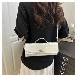 Detailed back view of white crocodile pattern baguette bag with gold twist buckle