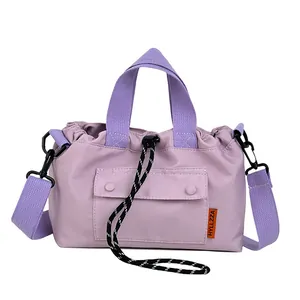 Light purple nylon crossbody bag with drawstring closure and contrasting woven straps