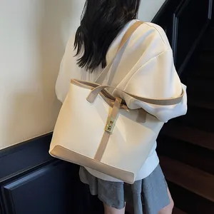 Contrast color tote bag in cream and khaki with a gold metallic clasp for daily commute