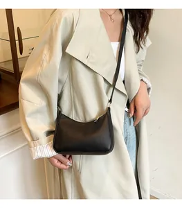 Chic black half-moon crossbody bag shown on model for a trendy minimalist look
