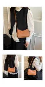 Close-up of caramel brown minimalist underarm bag with smooth texture and zipper detail